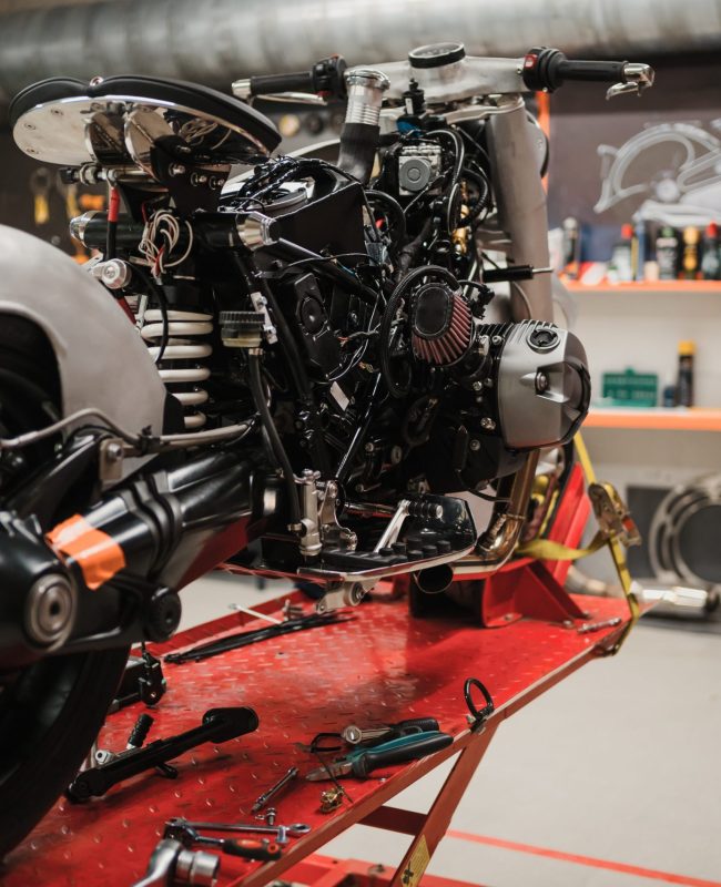 Fixing Custom motorcycle standing in repair shop. Instruments and equipment. Hobbies and unique Jobs